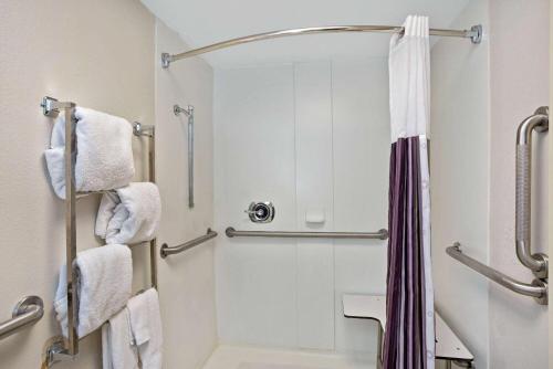 a bathroom with a shower with white towels at La Quinta by Wyndham New Haven in New Haven
