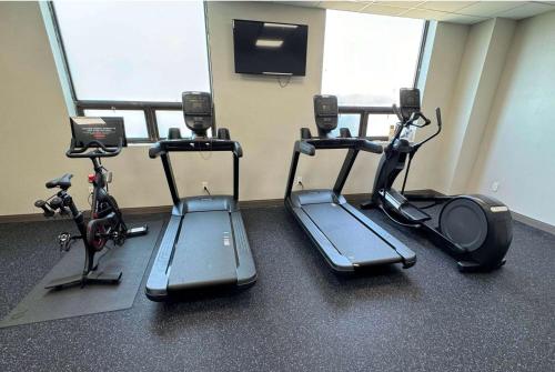 a gym with three exercise bikes and a flat screen tv at La Quinta by Wyndham New Haven in New Haven