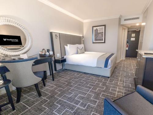 a hotel room with a bed and a desk at Southern Sun The Cullinan in Cape Town