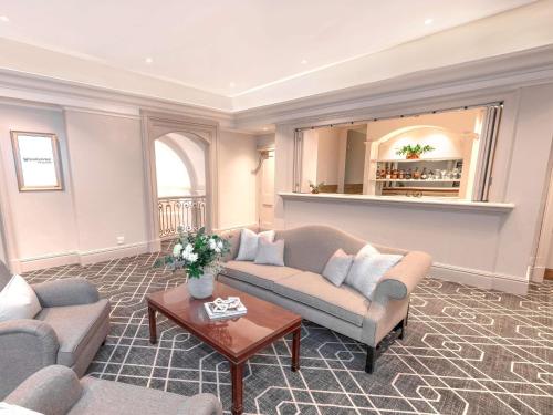 a living room with two couches and a table at Southern Sun The Cullinan in Cape Town