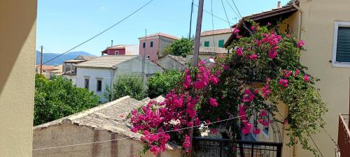 a bunch of pink flowers on the side of a building at Traditional two level Apartment in Liapades