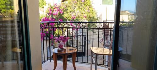 a balcony with a table and a vase of flowers at Traditional two level Apartment in Liapades