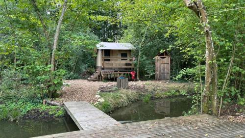 a cabin in the woods next to a river at Lodges insolites chez RDV en Terre Animale in Sury-aux-Bois