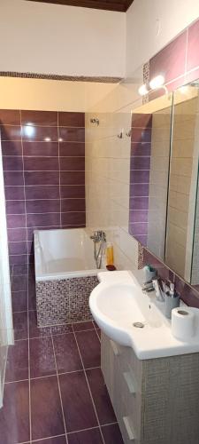 a bathroom with a tub and a sink and a mirror at Traditional two level Apartment in Liapades