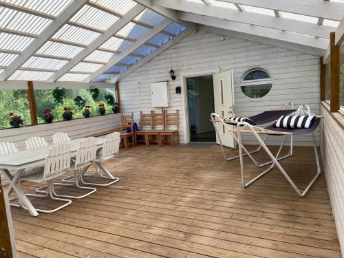 a patio with a table and chairs on a deck at Stor lägenhet ovanpå café ute på landet in Hökerum