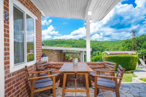 a patio with a wooden table and chairs at Hotel Anchor in Sinemorets