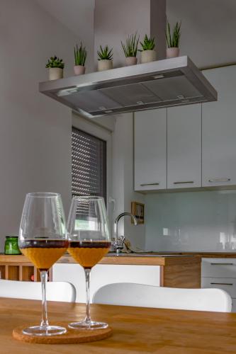 two glasses of wine sitting on a table in a kitchen at Hacienda R - kuca sa bazenom in Siokovac