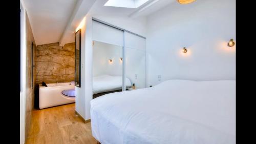 - une chambre avec un lit blanc et une baignoire dans l'établissement Duplex centre historique Cannes, à Cannes