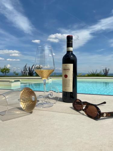 a bottle of wine next to a glass and sunglasses at Hacienda R - kuca sa bazenom in Siokovac