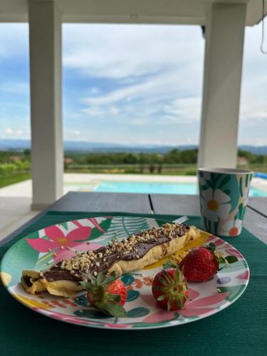 a plate of food with strawberries on a table at Hacienda R - kuca sa bazenom in Siokovac