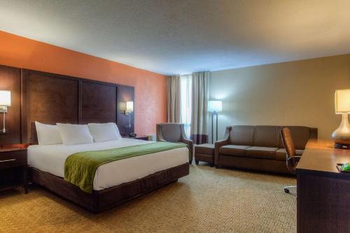 a hotel room with a bed and a couch at Comfort Inn & Suites Evansville Airport in Evansville