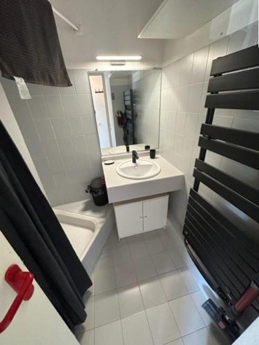 une salle de bain blanche avec un lavabo et un miroir dans l'établissement Secteur Golf Appartement t2 pour 4 personnes N52, à La Grande Motte