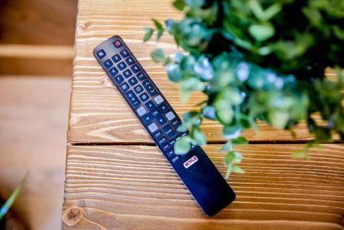 a remote control sitting on top of a wooden table at Podtatrzańskie Apartamenty in Nowy Targ