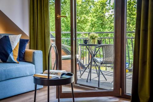 a living room with a blue couch and a glass door at Podtatrzańskie Apartamenty in Nowy Targ