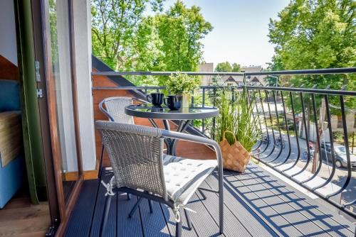 a balcony with two chairs and a table on it at Podtatrzańskie Apartamenty in Nowy Targ