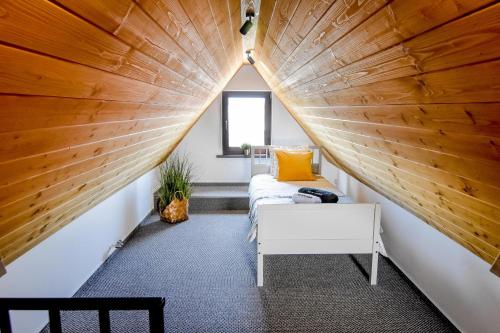 an attic bedroom with a large wooden ceiling at Podtatrzańskie Apartamenty in Nowy Targ