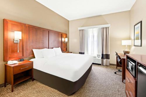 a hotel room with a large bed and a desk at Comfort Suites Abingdon I-81 in Abingdon