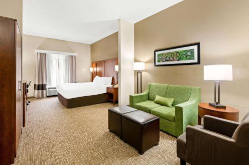 a hotel room with a bed and a green chair at Comfort Suites Abingdon I-81 in Abingdon