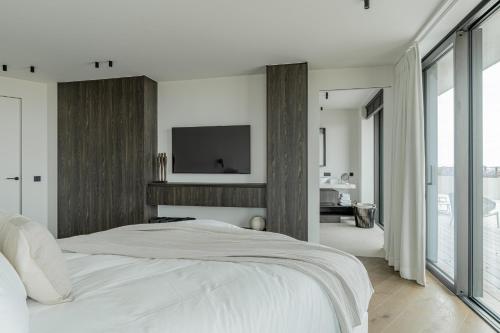 a bedroom with a bed with a tv on the wall at Enso District Residences in Knokke-Heist