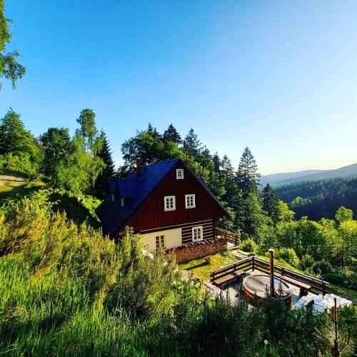 a red house with a blue roof on a hill at Kajzrovka in Rokytnice nad Jizerou