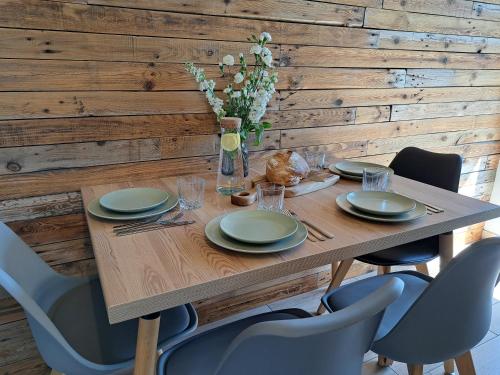 a wooden table with chairs and a wooden wall at 4 Pokoje Swory in Swornegacie 