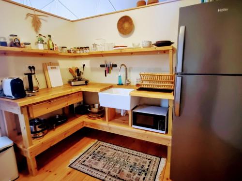 a kitchen with a stainless steel refrigerator and a sink at הבוסתן של הדס, הדום שבהר in Yavneʼel