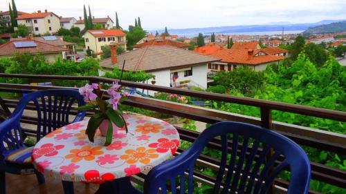 a table with a vase of flowers on a balcony at Apartma Vitez in Izola