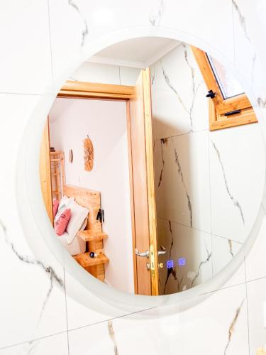 a round mirror in a room with a bedroom at Village View Apartments in Himare
