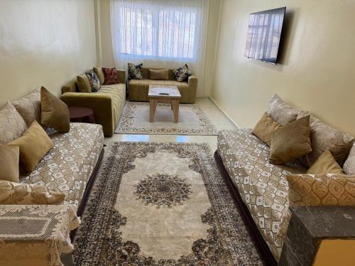 a living room with two couches and a table at Downtown Fez Delight Apartment in Fez