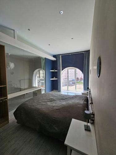 une chambre avec un grand lit et une grande fenêtre dans l'établissement Le loft K- centre Colmar - jusqu'à 10 personnes, à Colmar