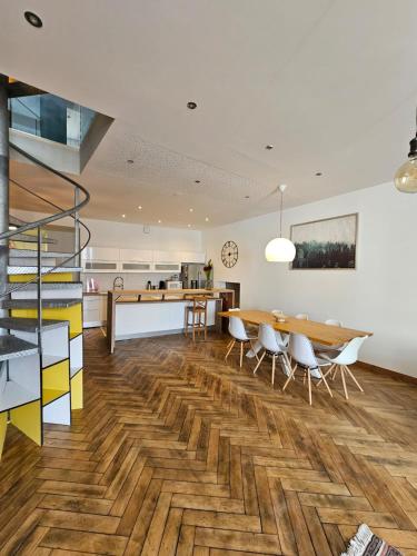 une cuisine et une salle à manger avec une table et des chaises en bois dans l'établissement Le loft K- centre Colmar - jusqu'à 10 personnes, à Colmar