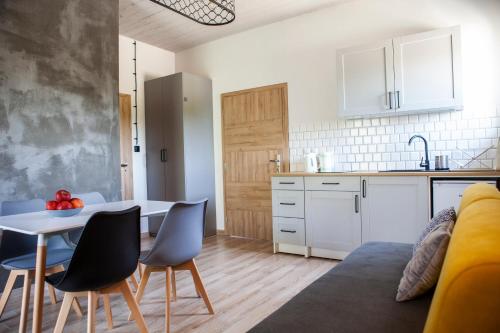 a kitchen and living room with a table and chairs at 4 Pokoje Swory in Swornegacie 