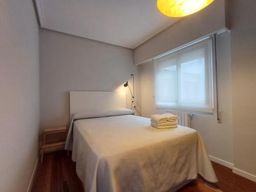 - une chambre avec un lit et 2 serviettes pliées dans l'établissement 4L - Ourense Centro con garaje, à Ourense