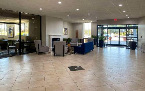 a lobby with a waiting area with chairs and tables at MainStay Suites Conover-Hickory in Conover