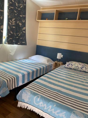 deux lits côte à côte dans une pièce dans l'établissement U Sortipiani, à Sortipiani