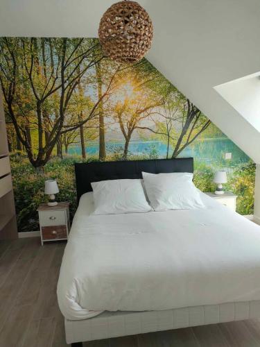 une chambre avec un lit avec un tableau sur le mur dans l'établissement AU BON ACCUEIL A PORCARO AVEC ACCES au SPA EN ILLIMITE, à Porcaro