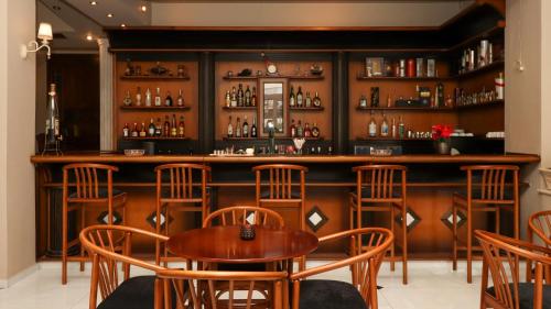 a bar with wooden chairs and a wooden table at Hotel Orfeas in Kalabaka