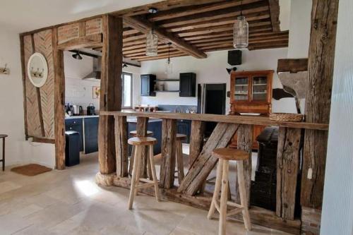 a kitchen with a counter and stools in a room at Lodges insolites chez RDV en Terre Animale in Sury-aux-Bois