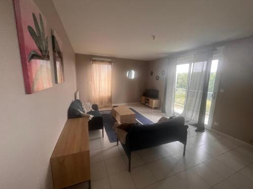 un salon avec deux canapés et une table dans l'établissement Appartement rénové avec grande terrasse, à Cesson-Sévigné