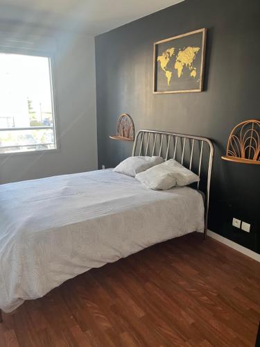 - une chambre avec un lit et une carte murale dans l'établissement Appartement rénové avec grande terrasse, à Cesson-Sévigné