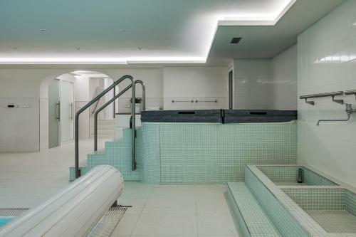 a bathroom with a tub and a sink and stairs at Vila Zlatý Slavík - Luxurious Villa with Spa in Jevany