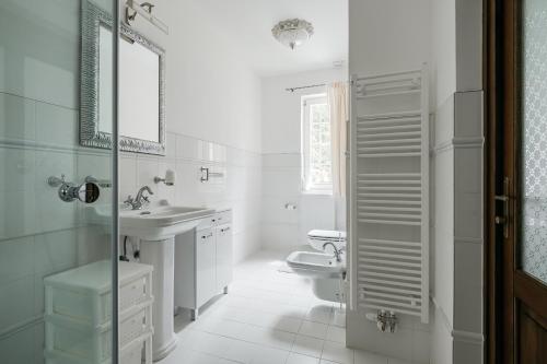 a white bathroom with a toilet and a sink at Vila Zlatý Slavík - Luxurious Villa with Spa in Jevany