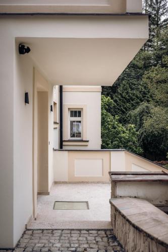 a white house with a window and a walkway at Vila Zlatý Slavík - Luxurious Villa with Spa in Jevany