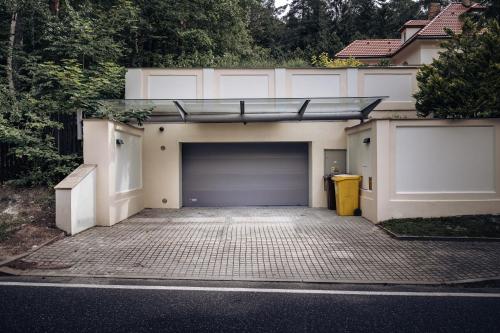 a garage with a garage door and a parking lot at Vila Zlatý Slavík - Luxurious Villa with Spa in Jevany