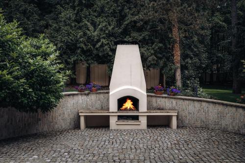 a outdoor oven with a fire in a stone wall at Vila Zlatý Slavík - Luxurious Villa with Spa in Jevany