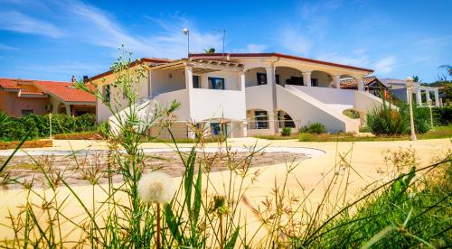 a white house with a red roof at Sardiniarooms Arbatax Beach in Àrbatax