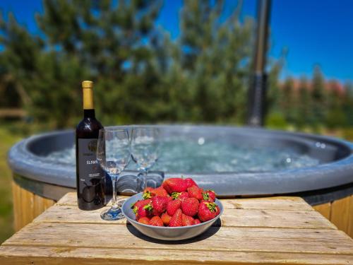 a bowl of strawberries next to a bottle of wine and a bowl of strawberries gmaxwell at 4 Pokoje Swory in Swornegacie 