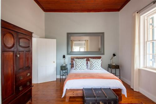 a bedroom with a bed and a dresser and a mirror at Rus In De Rust in De Rust