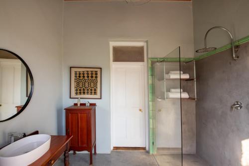a bathroom with a shower and a sink and a mirror at Rus In De Rust in De Rust