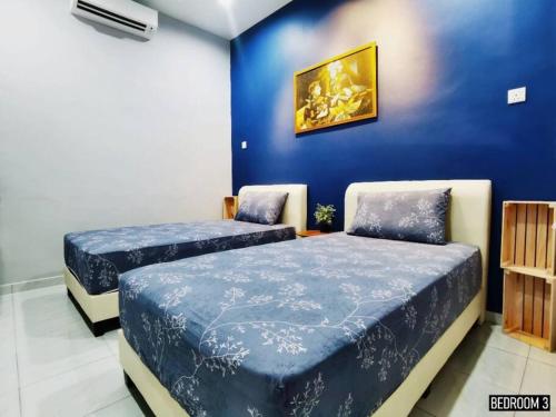 two beds in a room with a blue wall at 11pax5br Modern 5mins Ipoh Town wPoolTable in Ipoh